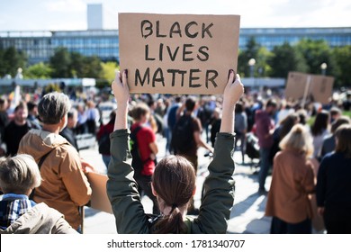 Rear view of black lives matters protesters holding signs and marching outdoors in streets. - Shutterstock ID 1781340707