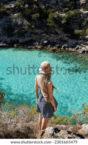 Rear view of blonde woman with hat in cala pi, mallorca, balearic islands