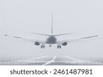 Rear view of a Boeing 737 airplane about to land at the airport on a foggy morning.