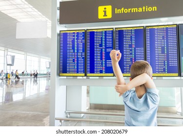 Rear View Of A Bored Kid Crossing His Arms And Looking Panel Flight Times In The Airport