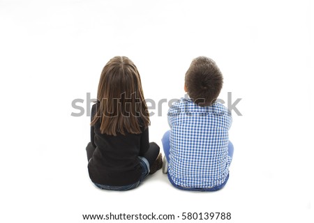 Rear view of boy and girl looking up, sitting on floor. Isolated on white background
