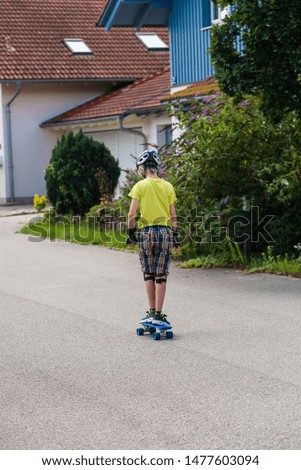 Similar – Young man riding on skate and holding surfboard