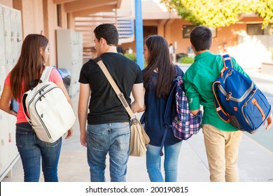 Rear view of a bunch of high school students walking down the hallway