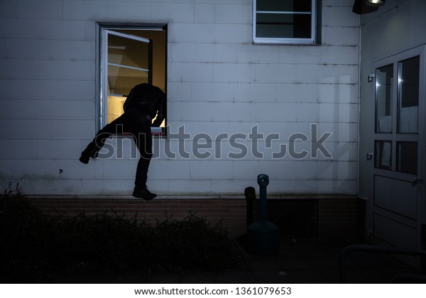 Rear View Burglar Entering House Through Stock Photo (Edit Now) 1361079653