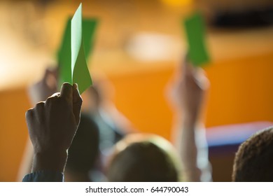 Rear view of business executives show their approval by raising hands at conference center - Powered by Shutterstock