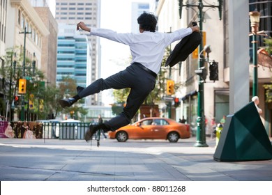 Rear View Of Business Man Jumping In Air And Kicking Heals