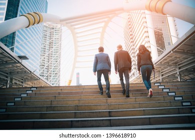 Rear view of business team climbing stairs go to a city. Business concept