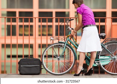 rear view of business woman locking padlock to her bike. Copy space - Powered by Shutterstock