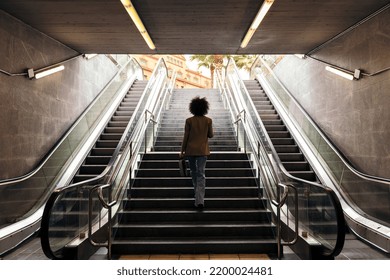 Rear View Of Business Woman Walking Up The Stairs