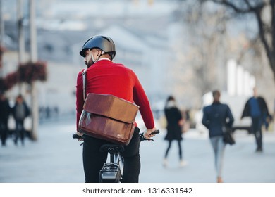 A Rear View Of Businessman Commuter With Electric Bicycle Traveling To Work In City.