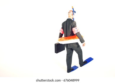 Rear View Of A Businessman In Flippers; Inflatable Rubber Ring; Snorkel And Goggles Holding Briefcase Against White Background