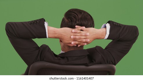 Rear view of businessman leaning back in office chair on green screen