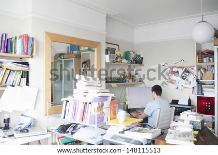 Rear view of businessman using computer in creative office space
