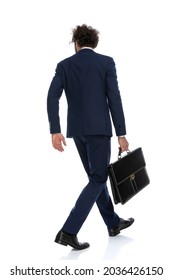 Rear View Of A Businessman Walking One Way And Looking The Other Way While Holding A Briefcase