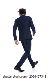 Rear View Of A Businessman Walking One Way And Looking The Other Way Against White Background