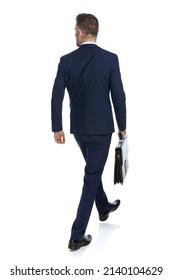 Rear View Of A Businessman Walking One Way And Looking The Other With A Case In Hand 