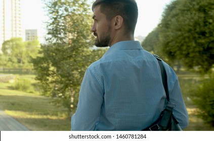 Rear view. Businessman walking in the park