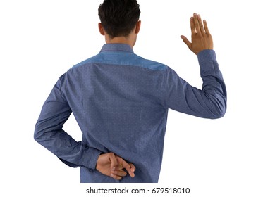 Rear view of businessman waving hand with crossed fingers while standing against white background - Powered by Shutterstock