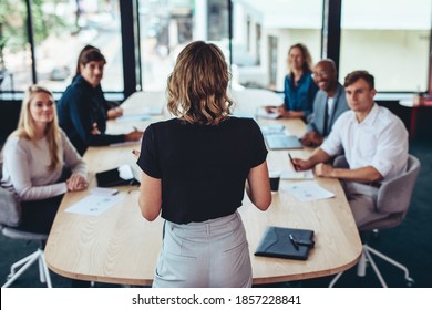 Rear view of a businesswoman addressing a meeting in office. Female manager having a meeting with her team in office boardroom. - Shutterstock ID 1857228841