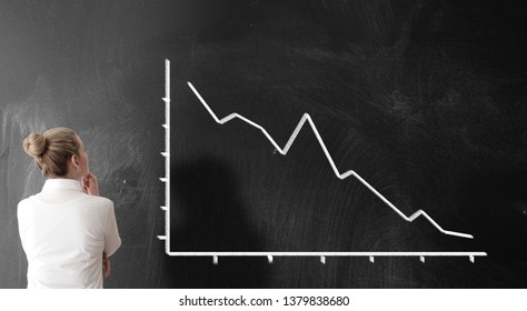 rear view of businesswoman looking at chart with sloping curve, dropping prices business risk concept