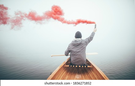 Rear view of canoeist using smoke bomb to signal his position in the haze