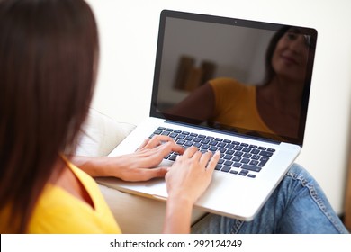 Rear View Of A Carefree Student Working On Laptop While Sitting