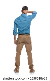 Rear View Of A Casual Guy Scratching His Head And Feeling Lost Against White Background