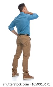 Rear View Of A Casual Man Scratching The Back Of His Neck And Thinking About Something Against White Background