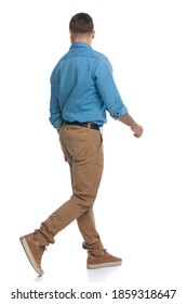 Rear View Of A Casual Man Walking One Way And Looking The Other Way Against White Background