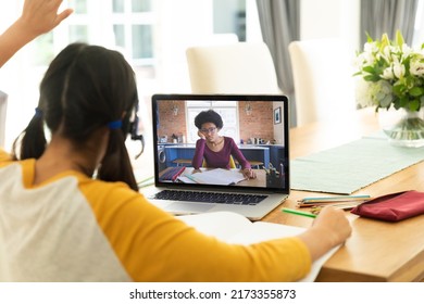 Rear View Of Caucasian Girl Raising Hand While African American Woman Teaching Online On Video Call. Laptop, Home, Unaltered, Childhood, Wireless Technology, Education, Student And E-learning.