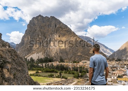 Rear view of caucasian man looking Inca Terraces and Hill in Ollantaytambo, Peru