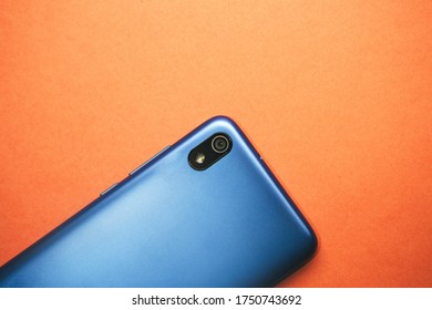 Rear View Cell Or Mobile Phone With A Camera On A Orange Background