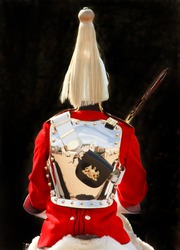 Rear View Of A Changing Of The Queens Life Guard Against A Black Background.  There Is A Nice Reflection Of Horse Guards Parade In His Shiny Breastplate. He Is From The Household Cavalry