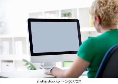 Rear view closeup of a young woman working of a computer