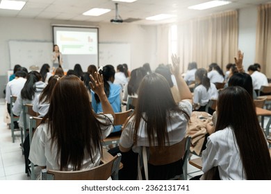 Rear view of college students listen to teacher teaching and explaining lesson in classroom - Powered by Shutterstock