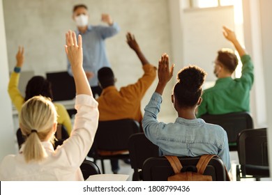 Rear view of college students raising hands to answer teacher's question during a lecture.  - Shutterstock ID 1808799436