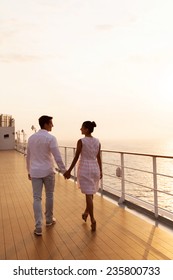 Rear View Of Couple Holding Hands Walking On Cruise Ship