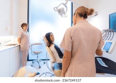 Rear view of a dentist explaining the procedure to a patient - Shutterstock ID 2367249137