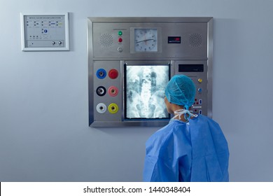 Rear view of diverse female surgeon examining x ray on x-ray light box at hospital. Healthcare workers in the Coronavirus Covid19 pandemic
 - Powered by Shutterstock