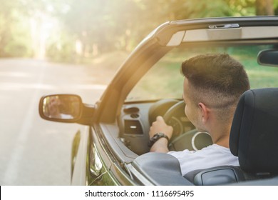 Rear view of driver driving a cabriolet car. On the road travel concept. - Shutterstock ID 1116695495