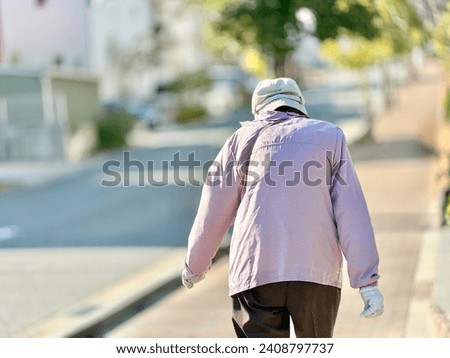 Rear view of an elderly woman walking in a residential area