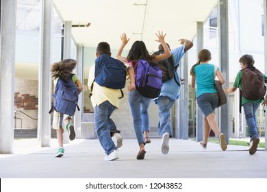 Rear View Of Elementary School Pupils Running Outside