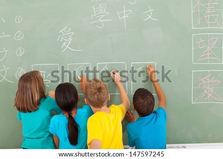 rear view of elementary school students learning chinese writing on chalkboard