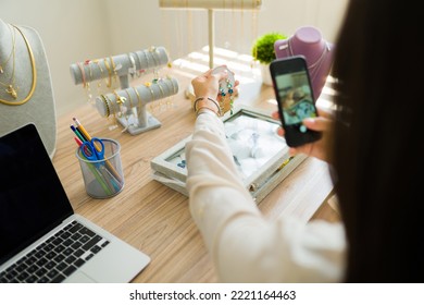 Rear view of an entrepreneur taking photos with her smartphone of the jewelry for her online store - Powered by Shutterstock