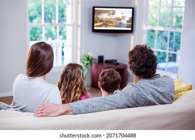 Rear View Of Family Sitting At Home Together Watching Golf Event On Tv. Sports, Competition, Entertainment And Technology Concept Digital Composite Image.