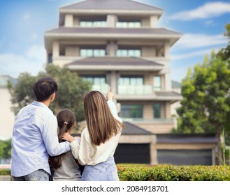 Rear View Of  Family Stand Outside Before Their New House 