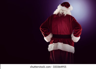 Rear View Of Father Christmas On Dark Background