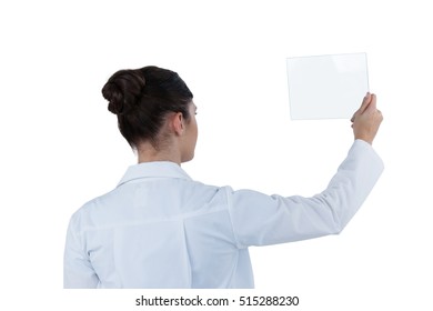 Rear view of female doctor holding digital tablet against white background - Powered by Shutterstock