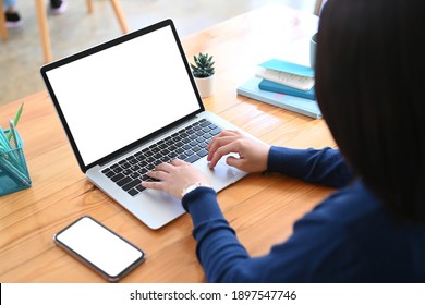 Rückansicht der freiberuflichen weiblichen Arbeit mit Laptop-Computer auf Holztisch.