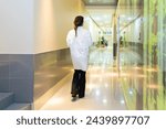 Rear view of a female ophthalmologist walking along a corridor in the clinic